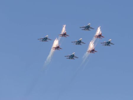 Moscow - May 7th, 2015: Beautiful plane aerobatic team Swifts and Russian Knights made the figure of a large diamond on a background of blue sky and fireworks released May 7, 2015, Moscow, Russiaのeditorial素材