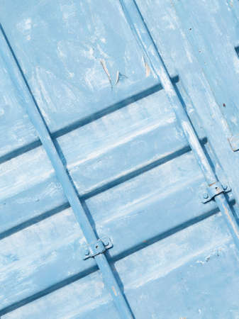 blue painted metal surface of old container with tubes, with peeling paint chipping on the street verticalの写真素材