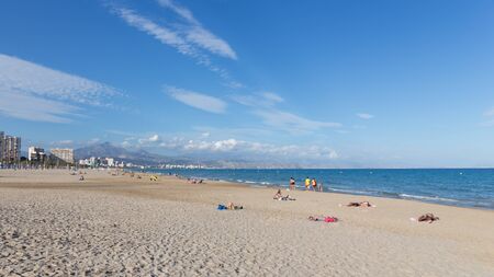 Alicante -13 October 2015: A lot of happy people relax and sunbathe at the beach in the evening in good weather October 13, 2015 Alicante, Spainのeditorial素材