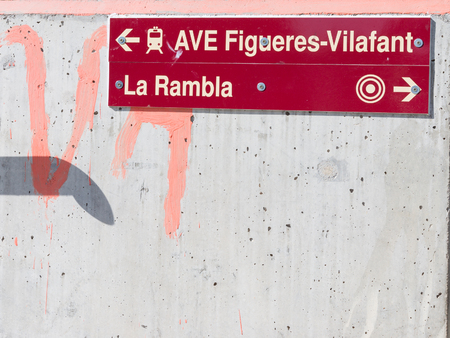 Barcelona - October 11, 2015: Red plate on a concrete wall transition arrows indicating the direction of the streets of Barcelona, October 11, 2015, Barcelona, Spainのeditorial素材