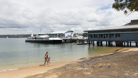 Sydney - March 1, 2016: Sydney Beach and the woman with the child walk with seagulls in sea water Sydney Harbour March 1, 2016, Sydney, Australiaのeditorial素材
