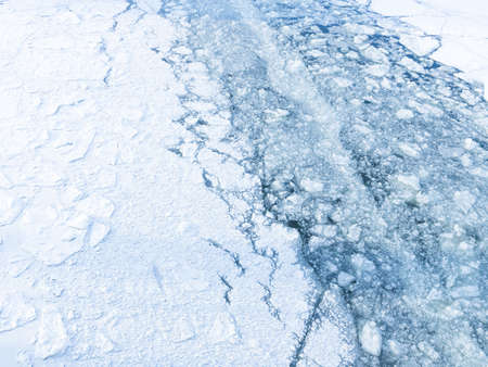 beautiful brittle ice cracked on the river and visible ice water and a lot of small pieces of ice in...