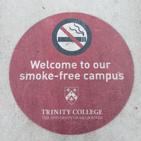 Melbourne - 22 February 2016: the inscription on the concrete road: welcome to our smoke-free campus and the emblem of the University of Melbourne, in the streets of the city February 22, 2016, Melbourne, Australiaのeditorial素材
