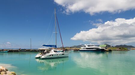 La Digue - 9 November 2014: The yacht and passenger ferry are in port and beautiful reflection in seawater November 9, 2014, La Digue, Seychellesのeditorial素材