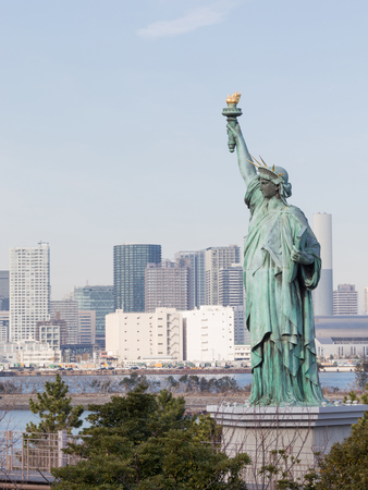Tokyo - 4 February 2015: Women's figure of the Statue of Liberty with torch in the background  of the urban landscape of Tokyo Bay, on 4 February 2015 in Tokyo, Japanのeditorial素材