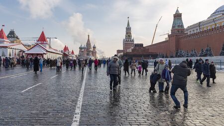 Moscow - January 7, 2016: Winter cityscape and people walk and take pictures on Red Square near the Lenin Mausoleum, Spasskaya Tower and St. Basil's Cathedral January 7, 2016, Moscow, Russiaのeditorial素材