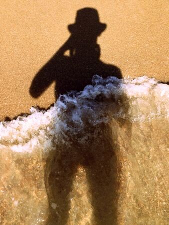shadow of photographing in the sand and in the sea wavesの写真素材