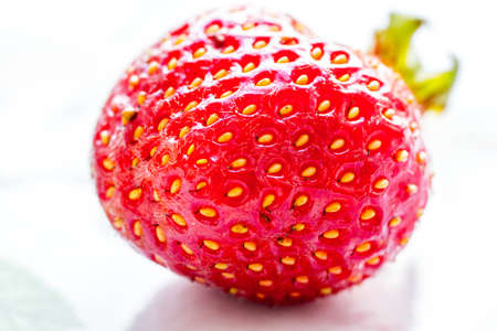 Strawberry close-up lying on white tableの写真素材