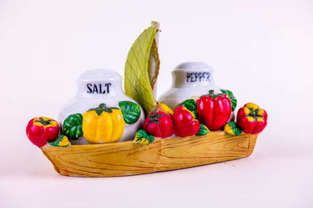 Salt and pepper shakers in the boat with vegetablesの写真素材