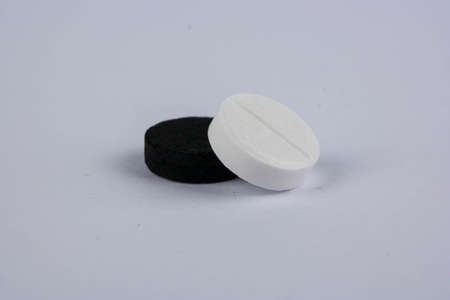 Black and white tablet lie on each other on gray background