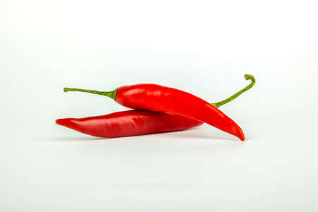 Two red chili peppers on white の写真素材