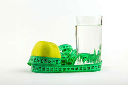 Green apple and glass of water wrapped meterの写真素材