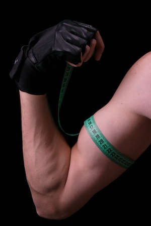 Measuring the volume meter biceps on black の写真素材