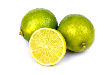 Three lime one of which is cut on a white backgroundの写真素材