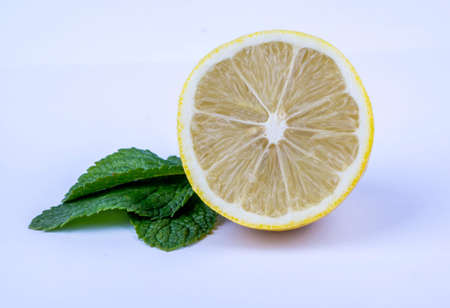 Half of lemon and mint leaves on a white background