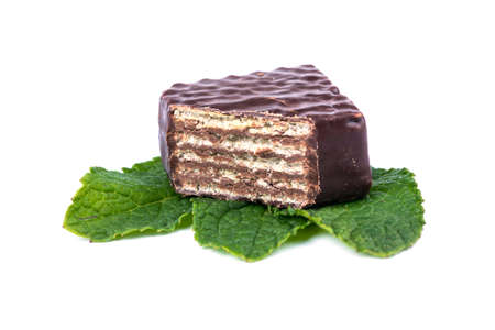 Chocolate candy cut in half on mint leavesの写真素材