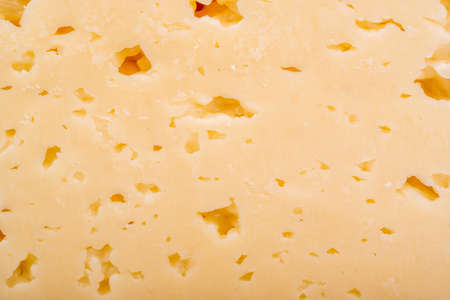Background of hard cheese with small holesの写真素材