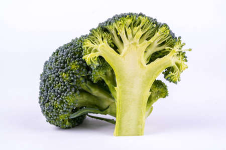 Two branches of broccoli, one of which cut in half
