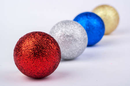 Four multi-colored Christmas balls on a white backgroundの写真素材
