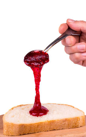 Raspberry jam dripping from a spoon breadの写真素材
