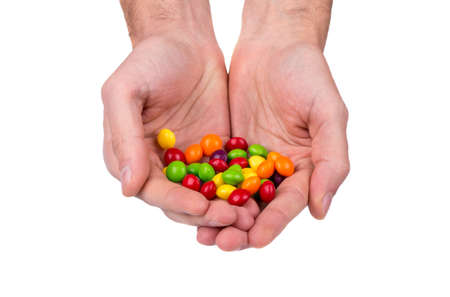 Pile of colorful candies in male handsの写真素材
