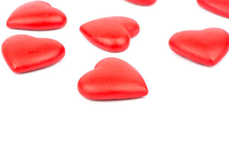 The scattered red heart made of plastic on a whiteの写真素材