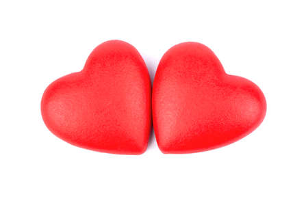 Two red hearts made of plastic on a white backgroundの写真素材