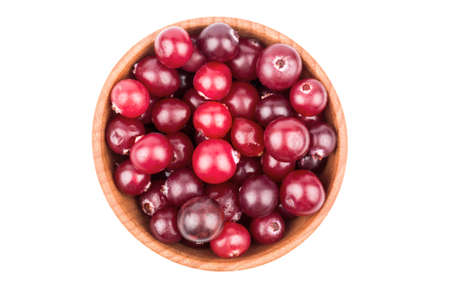Half a wooden bowl full of ripe red cranberry top viewの写真素材