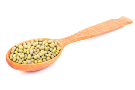 Green lentils in a wooden spoon on a white backgroundの写真素材