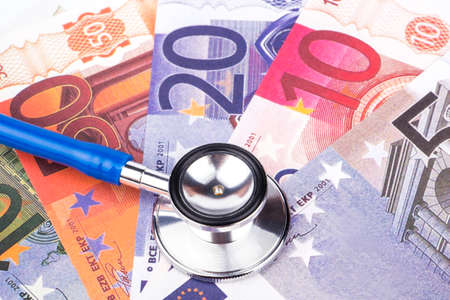 Medical stethoscope lying on euro banknotes various nominalの写真素材