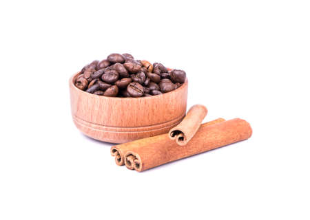 Coffee beans in a wooden bowl with cinnamon sticks on a white background
