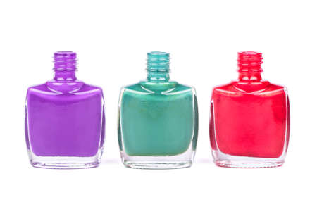 Three open bottles with colored nail polish on a white backgroundの写真素材