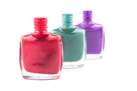Three open bottles with colored nail polish on a white backgroundの写真素材
