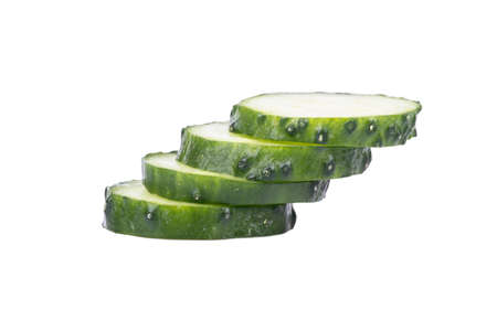 Several pieces of sliced green cucumber on a white backgroundの写真素材