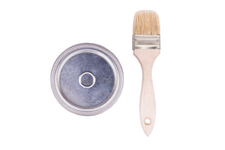 Paintbrush with a wooden handle lies near the paint cans top viewの写真素材