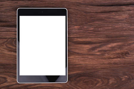 Tablet PC with a blank screen is a brown wooden background
