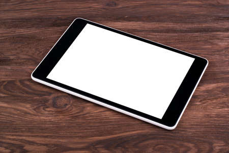 Tablet PC with a blank screen is a brown wooden background