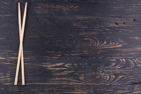 Chopsticks made of bamboo on a dark wooden backgroundの写真素材