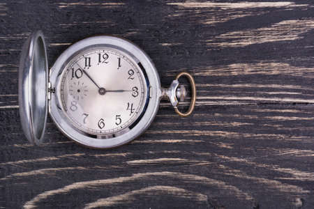 Opened old pocket watch on a dark wooden backgroundの写真素材