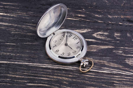 Opened old pocket watch on a dark wooden backgroundの写真素材