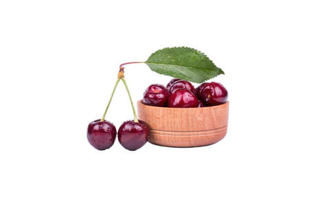 Fresh red cherries in a wooden bowl on a white backgroundの写真素材