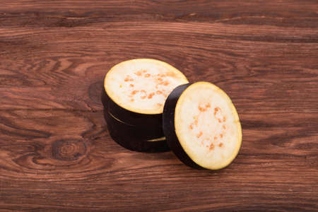 Sliced fresh eggplant on a brown wooden backgroundの写真素材