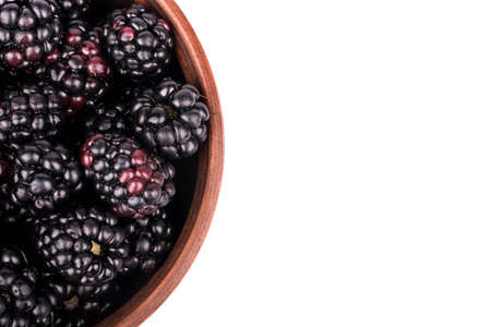Part of a full bowl of fresh blackberries on a white background top viewの写真素材
