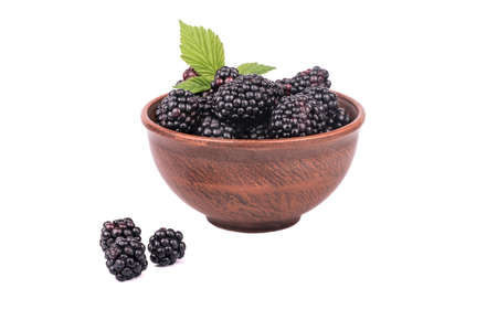 Full bowl of fresh blackberries with leaves isolated on a white backgroundの写真素材