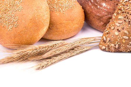 Spikelets of wheat with different kinds of bread on a white backgroundの写真素材