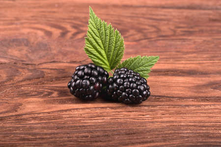 Two fresh blackberries with leaves on the wooden tableの写真素材