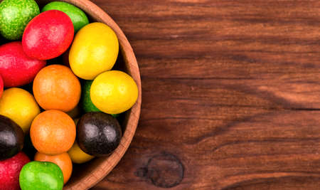 Part bowls full of colorful candies on a wooden backgroundの写真素材