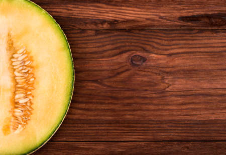 Part of cantaloupe melon halves fresh on a brown tableの写真素材
