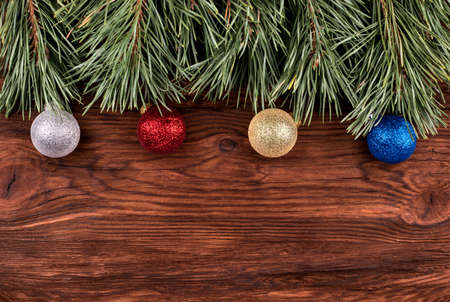 Pine branch with christmas toys on an empty wooden background for an inscriptionの写真素材