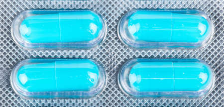 Four blue capsules in blister closeupの写真素材